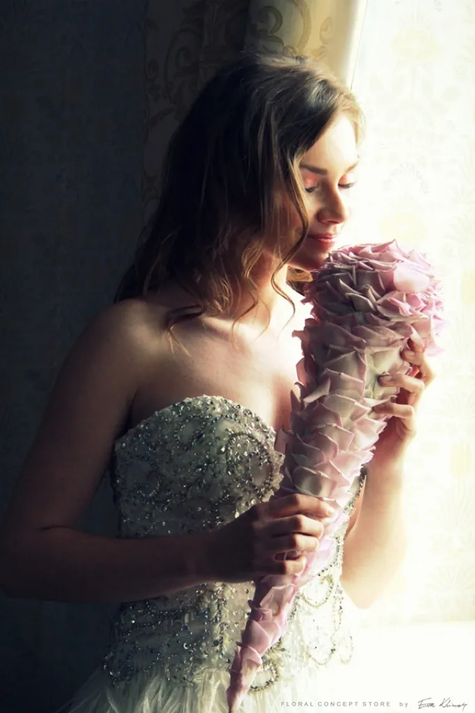 Romantyczny makijaż ślubny oraz fryzura ślubna wraz z bukietem kwiatów.