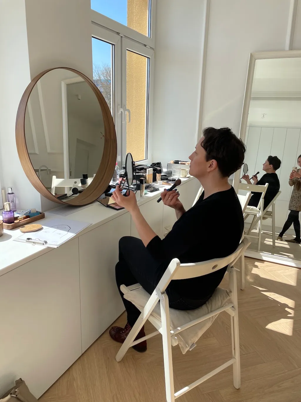 Kobieta malująca się przy lustrze rozpoczyna przygodę z makijażem w Krakowie